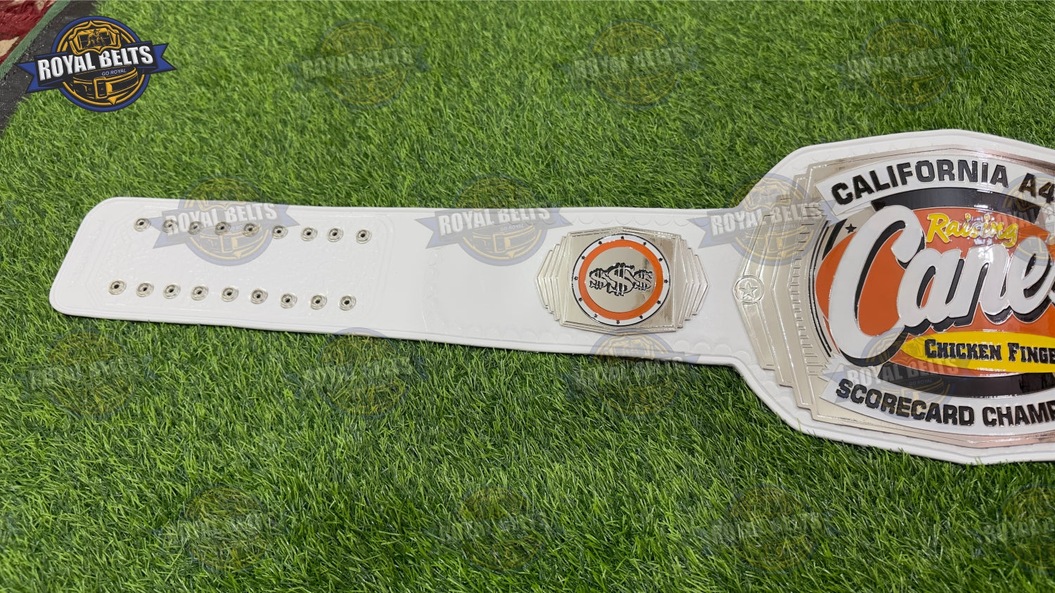 California Raising Cane’s championship belt with layered logo plates, polished brass finish