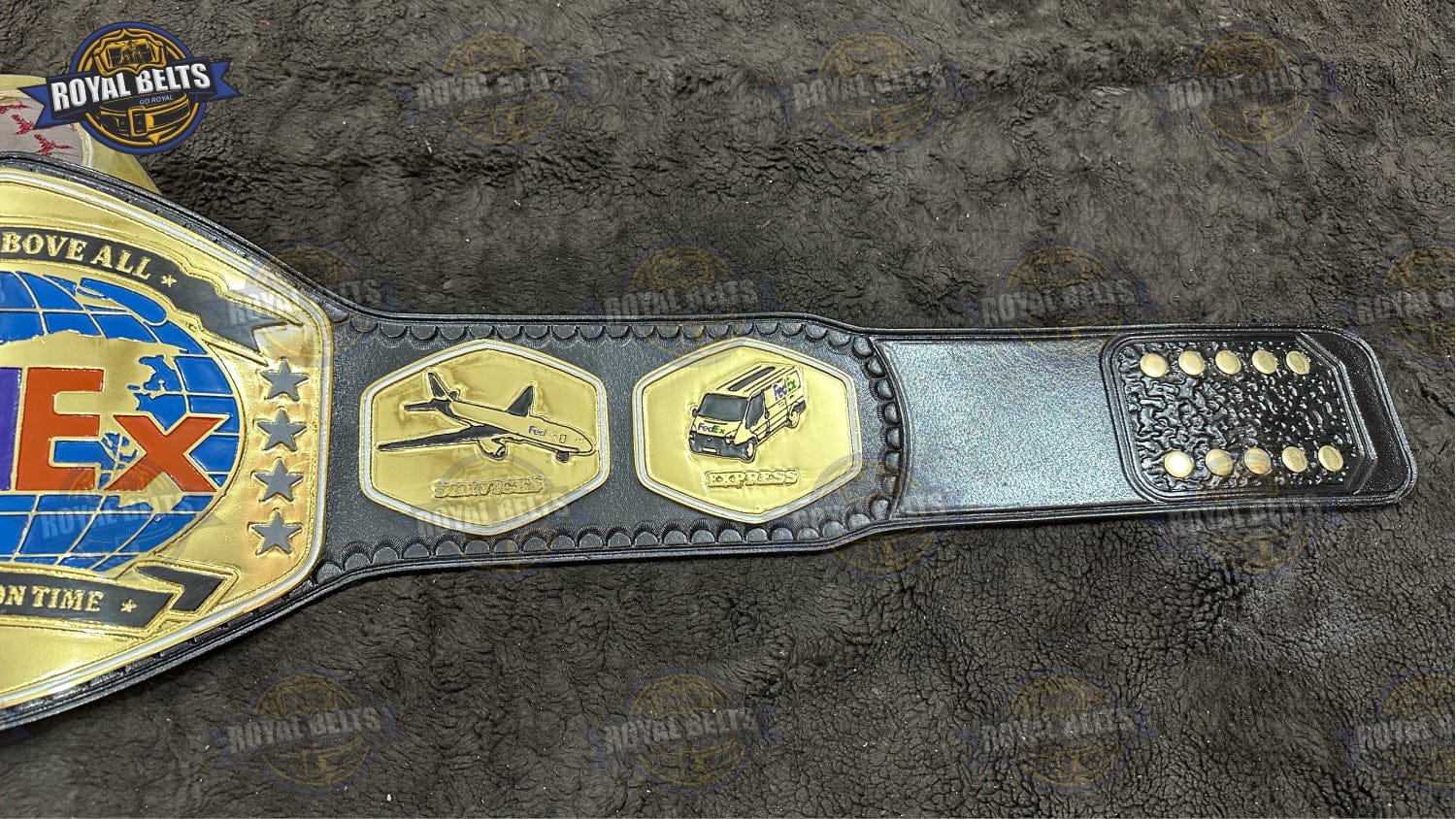 FedEx branded championship belt showing raised lettering and curved heavyweight plates
