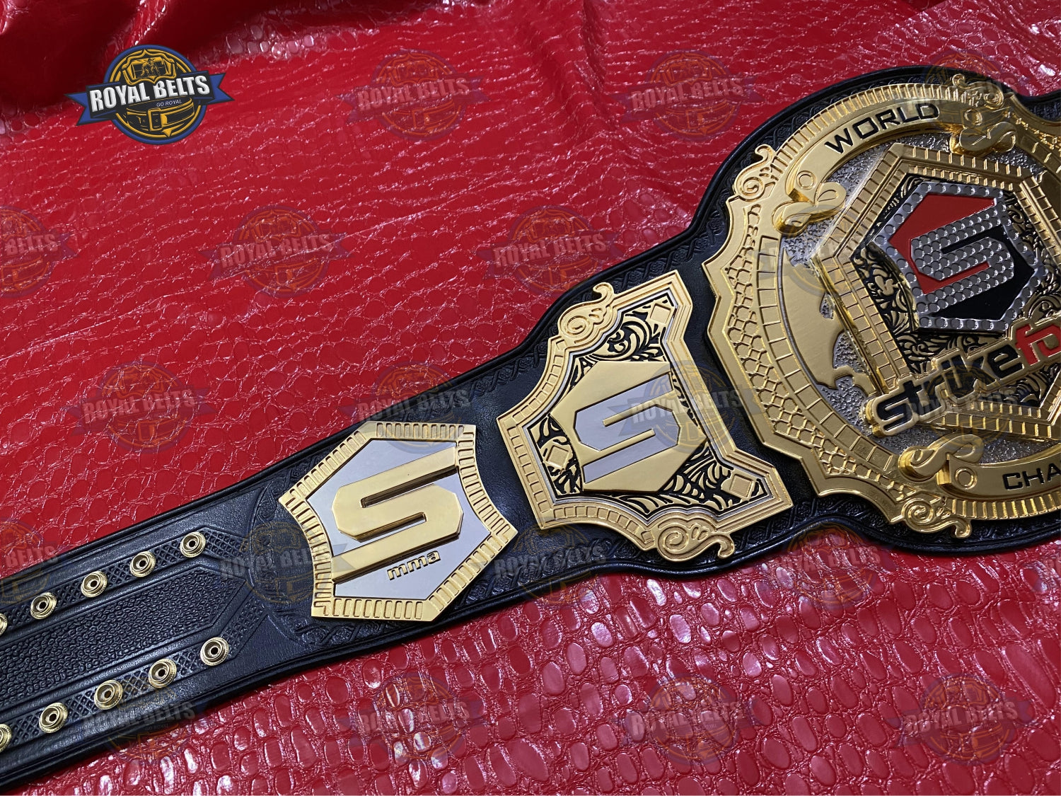Strikeforce title belt with beveled stacked plates, engraved lettering, adjustable stitched leather strap