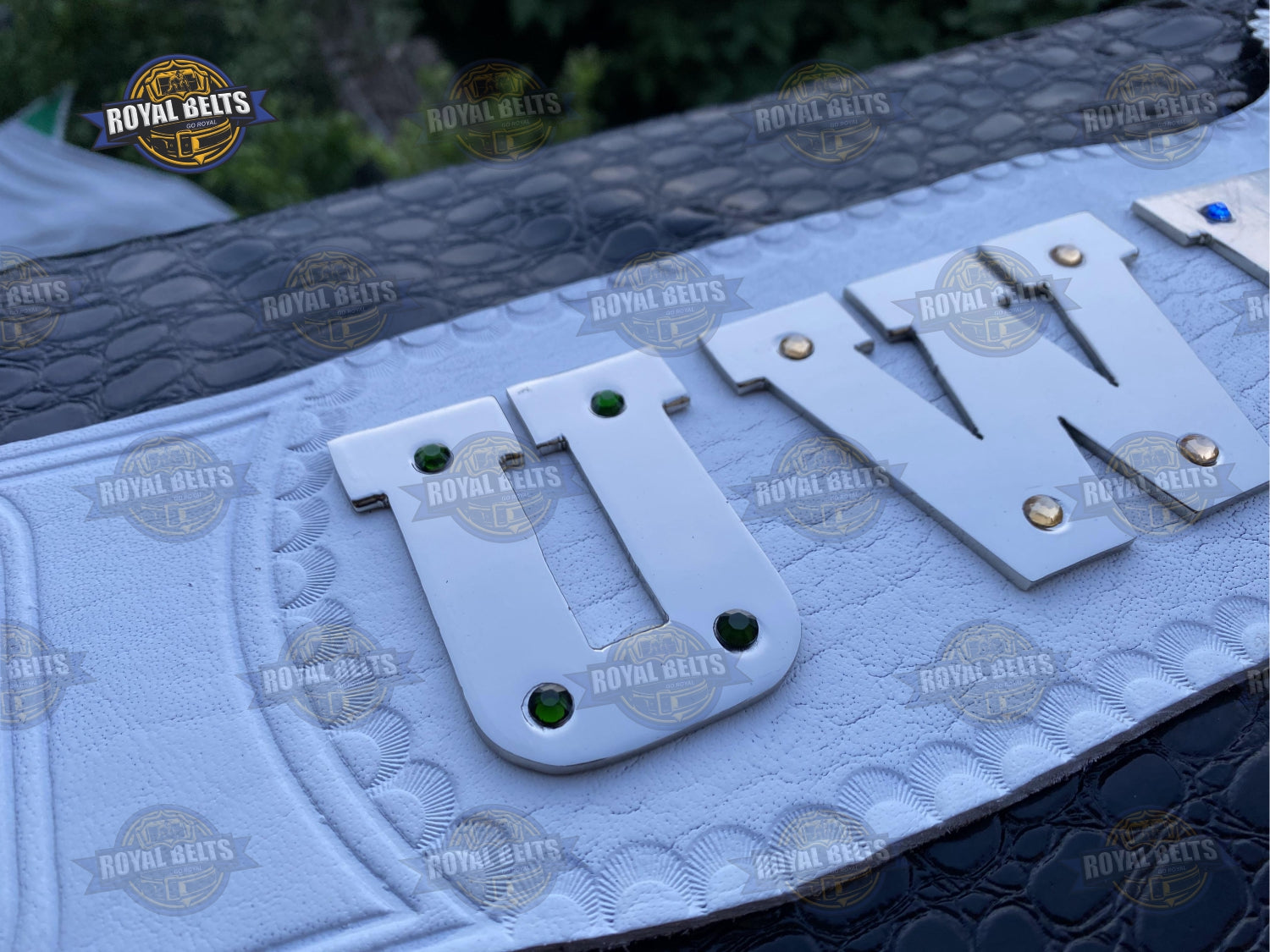 UWF title belt displaying engraved side plates, high quality chrome tone, reinforced white leather strap