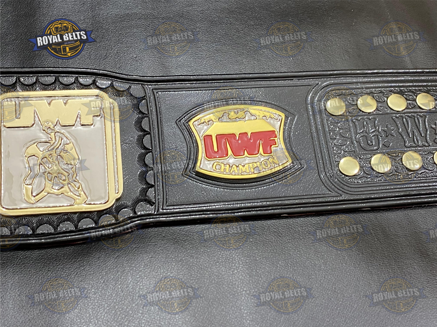 Custom UWF Heavyweight belt with raised gold center, mirror plated finish, embossed logos, stitched leather strap