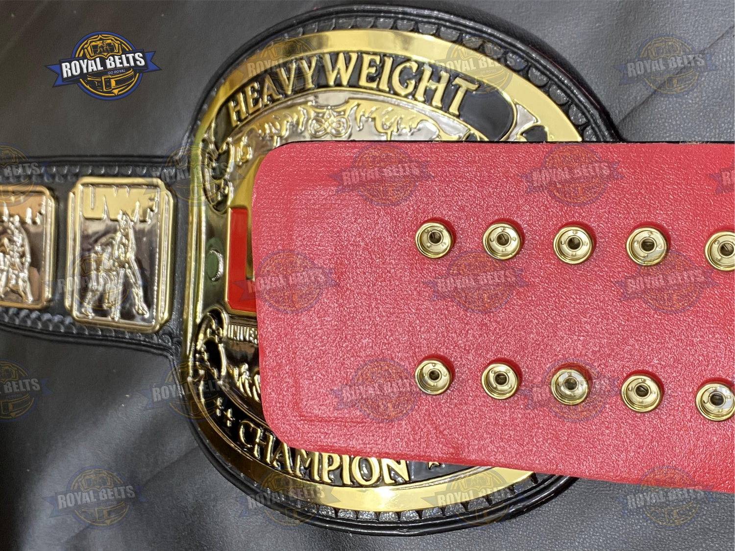 UWF belt with thick embossed center plate, layered gold side plates, black stitched leather strap