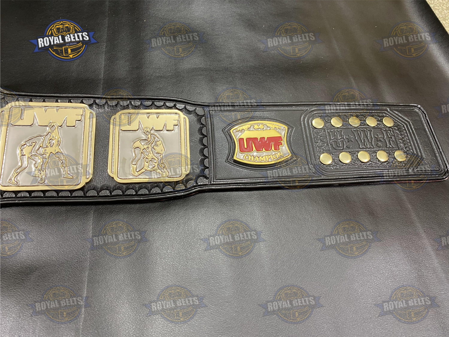 UWF belt with beveled gold center plate, HD CNC engraving, polished gold finish, adjustable black leather strap