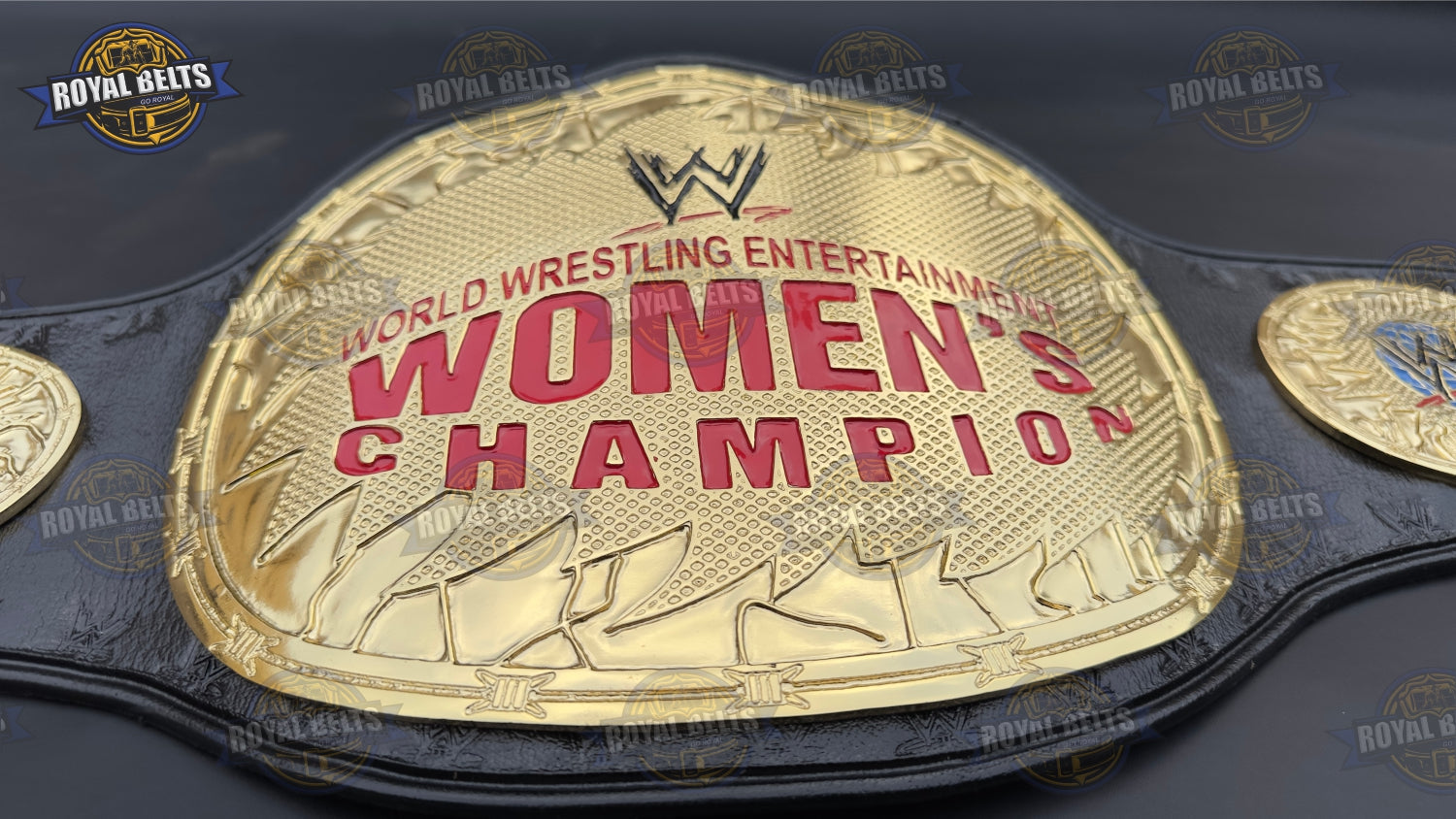 WWE Women’s championship belt displaying bold embossed center plate, thick metal build, snap fit leather